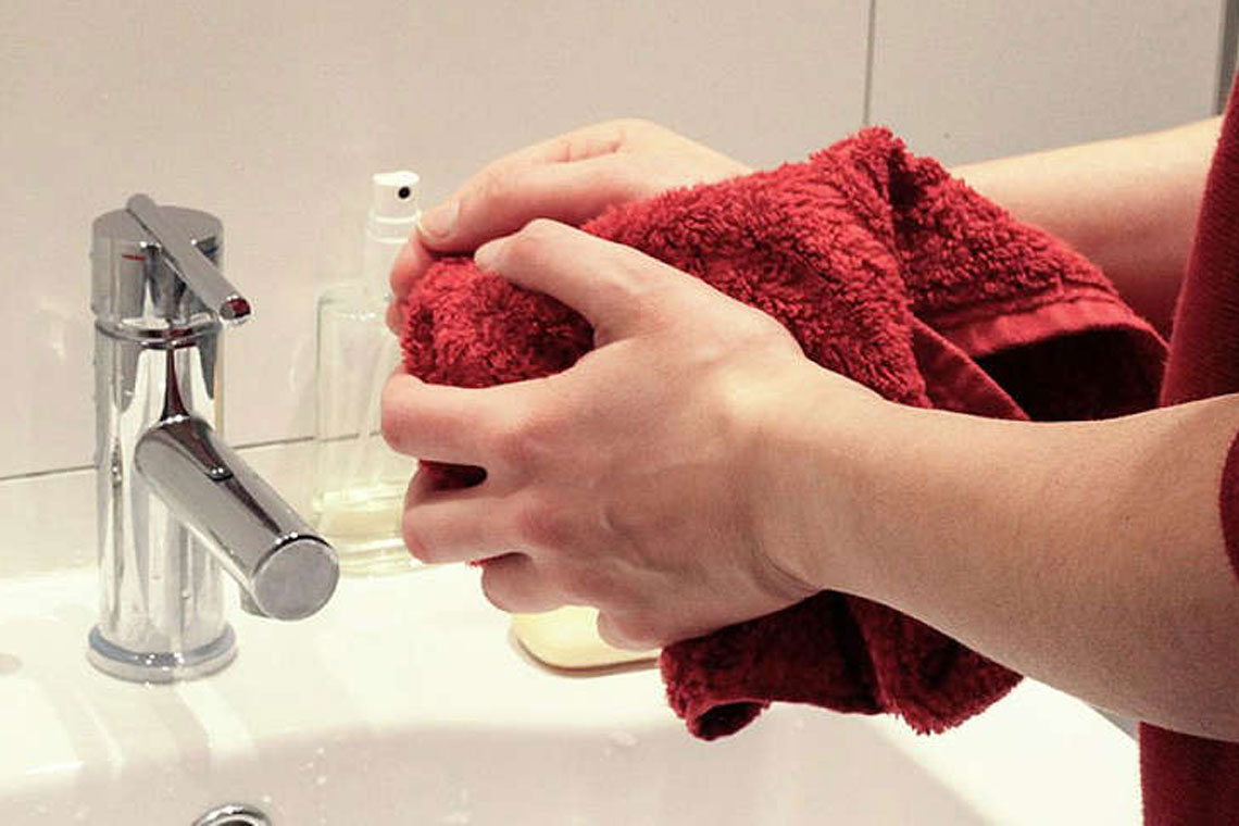 Ein Junge wäscht sich krampfhaft die Hände am Waschbecken
