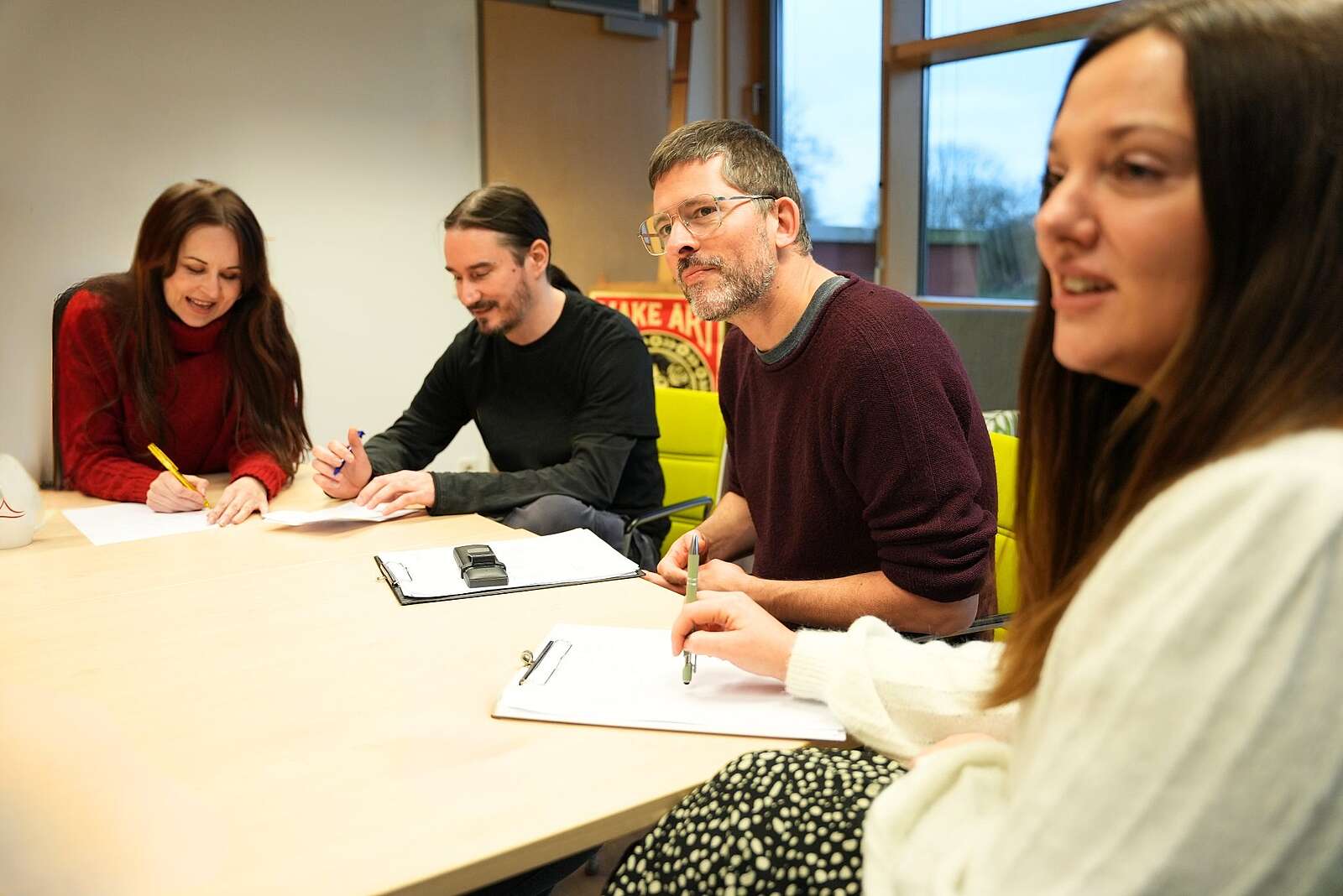 4 Mitarbeitenden sitzen am Tisch und besprechen etwas