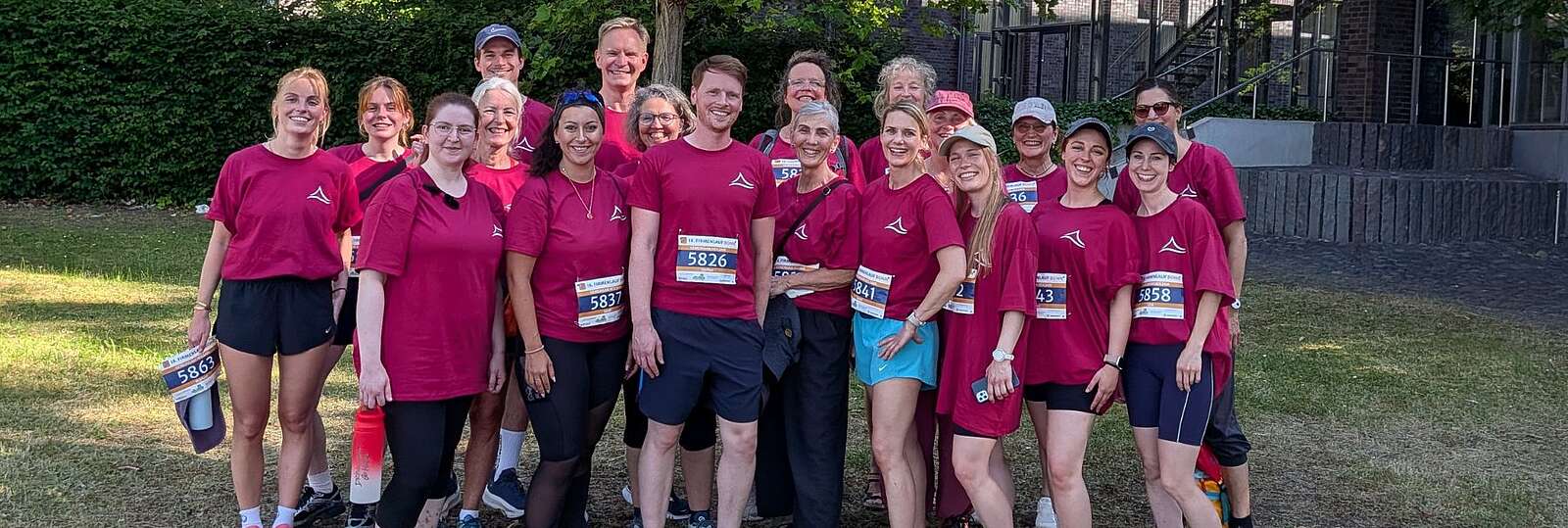 20 Kolleg:innen aus den Kliniken in Bonn und Wesseling in pinken Laufshirts beim Firmenlauf in Bonn. 